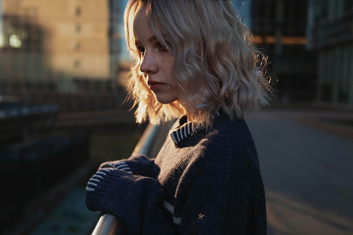photo of a girl standing on a bridge during sunset for a blog post about cinematic photography